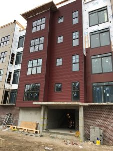 Street side view of Apartment building with large windows and sheet metal siding