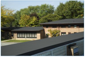 view of a building with brick walls and sheet metal roof